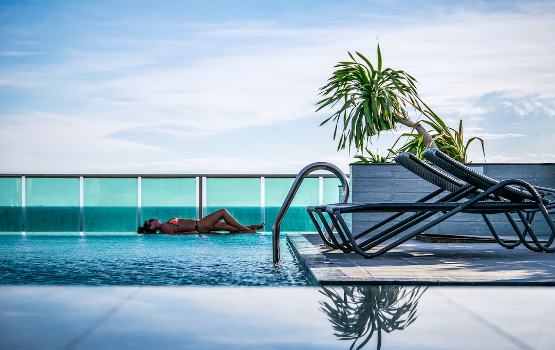 woman relaxing beside a rooftop pool at an exclusive private clubs venue in New York City