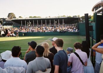 A tennis player competes in a US Open qualifying match on an outdoor hard court at Flushing Meadows