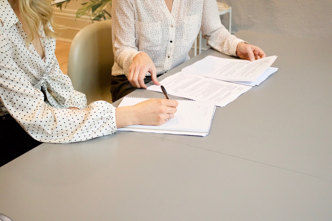 Two investors comparing NYC REITs portfolio options using printed property reports