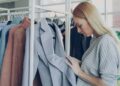 woman-browsing-sustainable-clothing-rack-unsplash - NYCwebzine A woman examines ethically made garments while building a capsule wardrobe at a New York City independent boutique