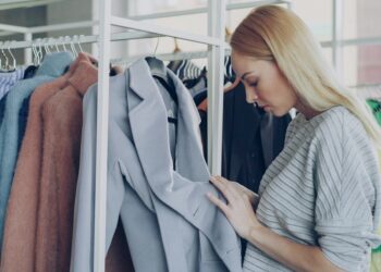 A woman examines ethically made garments while building a capsule wardrobe at a New York City independent boutique