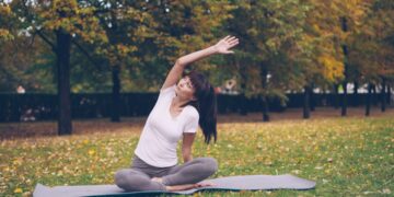 woman-doing-yoga-in-park-unsplash - NYCwebzine A woman practicing yoga on a mat at an outdoor fitness class in a New York City park