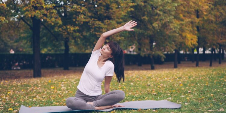 woman-doing-yoga-in-park-unsplash - NYCwebzine A woman practicing yoga on a mat at an outdoor fitness class in a New York City park
