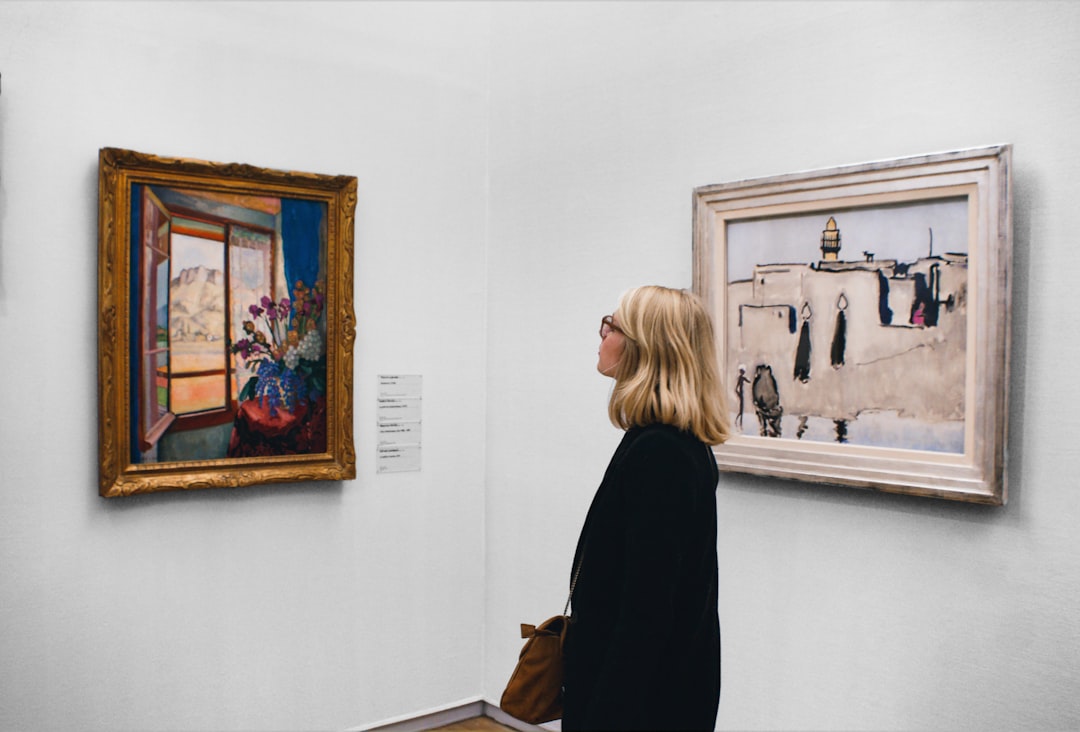 A collector examining a contemporary artwork at a gallery, reflecting the expert guidance offered by art advisors in NYC.