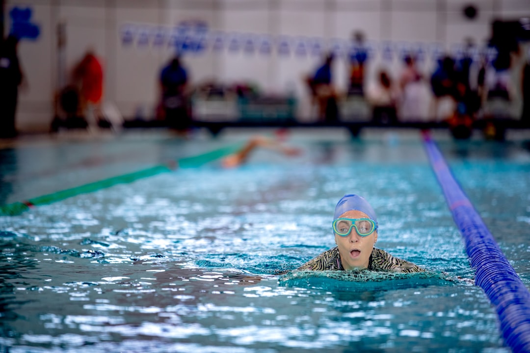 Adults swimming laps in an indoor pool, showing the year-round training routine of a swimming club in NYC