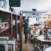 antique-furniture-person-unsplash - NYCwebzine A woman carefully inspects a vintage furniture piece in a Manhattan dealer showroom, evaluating provenance and condition