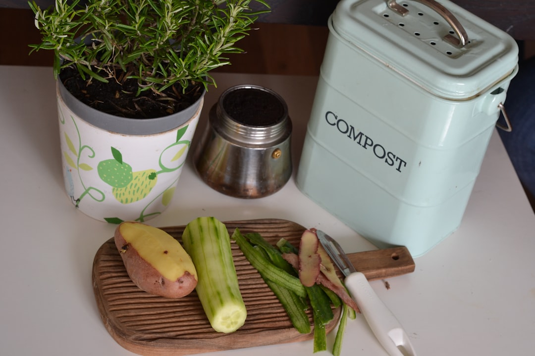 A woman adding vegetable peels to a countertop compost bin as part of her lower-waste kitchen routine in a city apartment