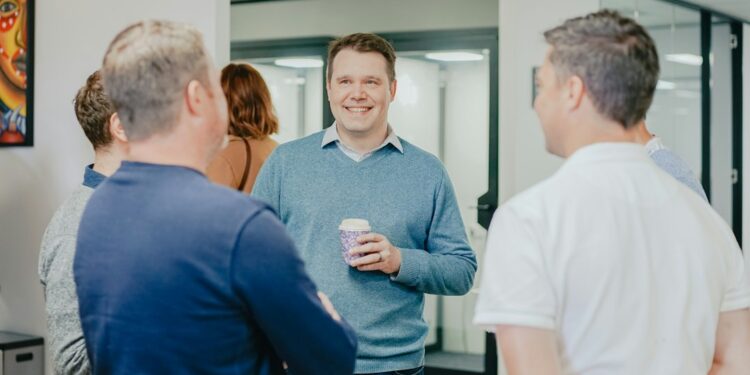 entrepreneur-talking-coffee-meeting-unsplash - NYCwebzine A founder having a face-to-face conversation with a potential first customer at a New York City café