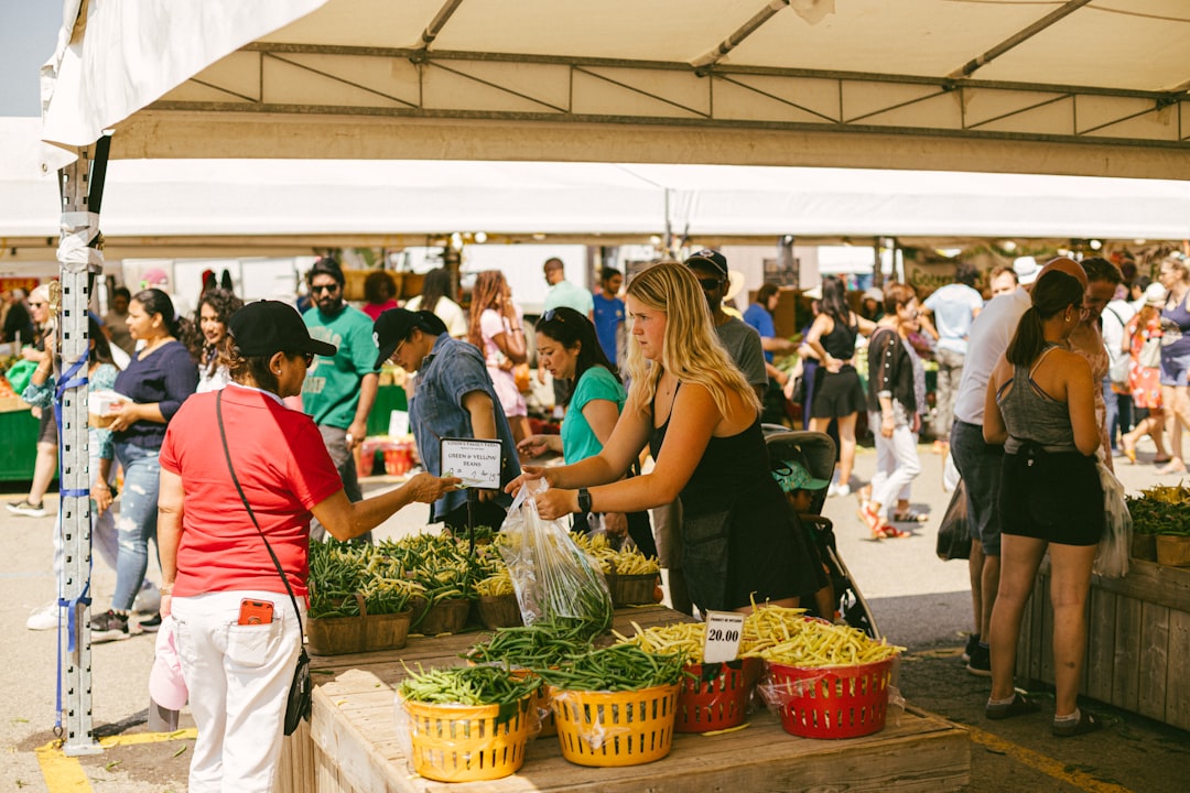 A person selecting fresh seasonal vegetables at a New York City farmers market to support a lower-waste kitchen lifestyle