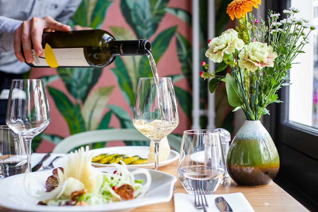 A sommelier pours wine alongside a truffle-topped dish at a New York City seasonal harvest tasting menu