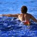 swimmer-entering-ocean-unsplash - NYCwebzine A swimmer wading into the open water at Brighton Beach, representing the open-water culture of a New York City swimming club