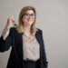 woman-signing-apartment-lease-with-keys-unsplash - NYCwebzine An NYC renter reviews a lease document at a table with a real estate agent in a Manhattan apartment