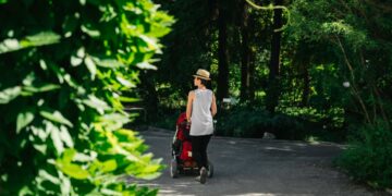 woman-walking-botanical-garden-path-unsplash - NYCwebzine A woman walks along a tree-lined path at one of New York City's botanical gardens in autumn