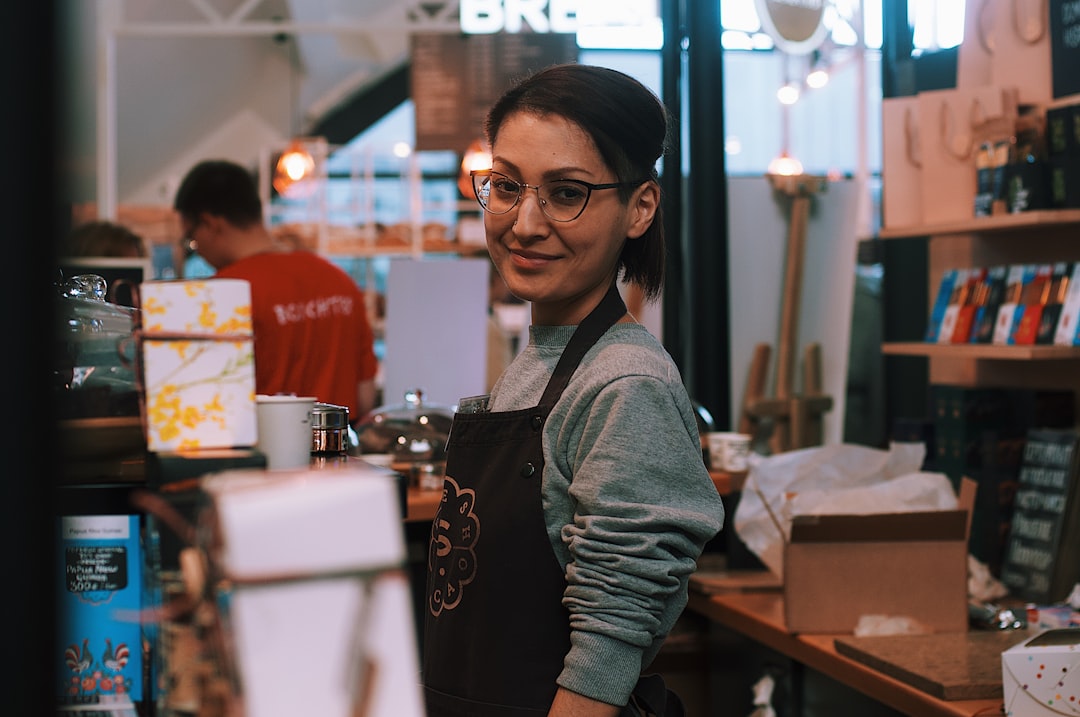 Uma mulher proprietária de negócio serve um cliente dentro de sua loja de propriedade de imigrante em Nova York