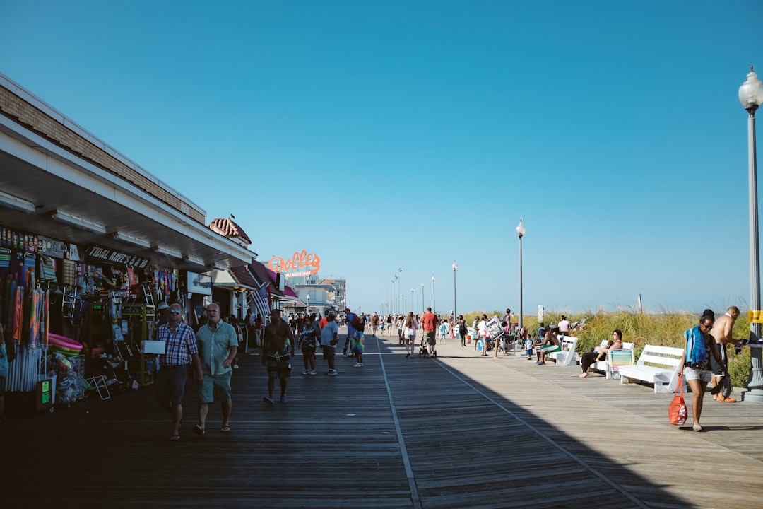 Una donna cammina lungo un soleggiato lungomare di Jersey Shore durante un viaggio nel fine settimana estivo da New York City