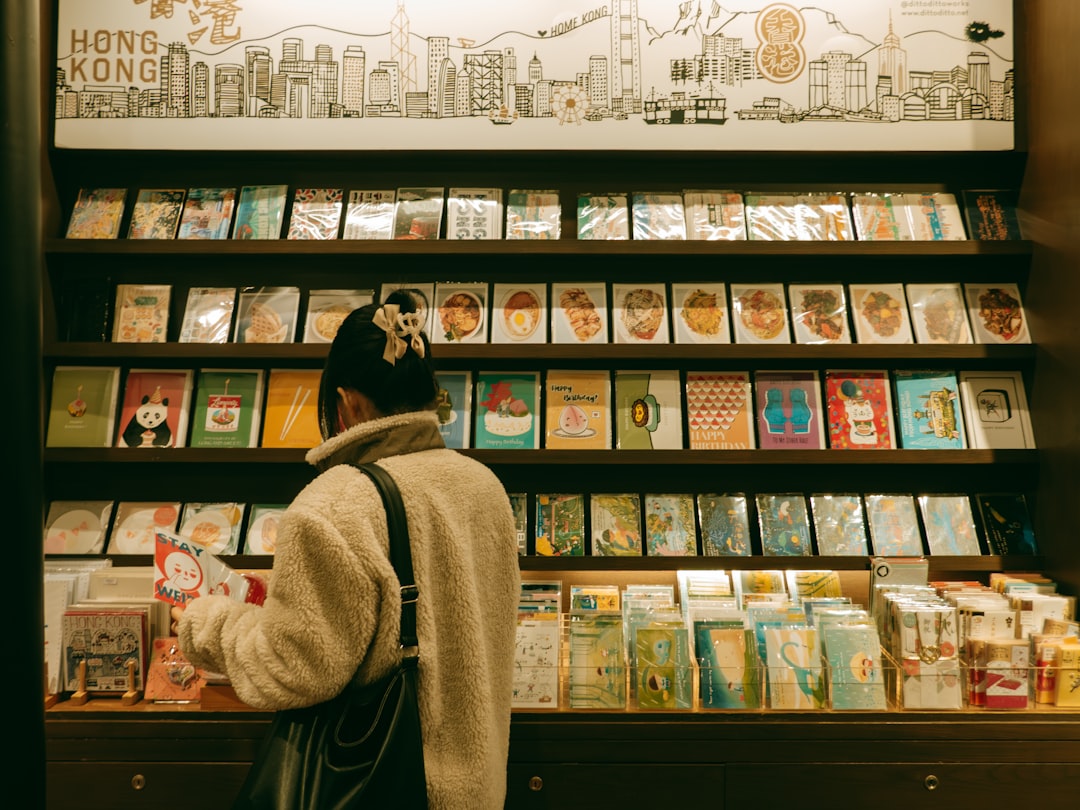 Un bambino piccolo che sfoglia libri illustrati in una delle migliori librerie per bambini di New York, circondato da scaffali colorati.