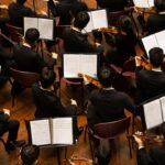 A conductor leads the Festival Orchestra of Lincoln Center in a Mostly Mozart concert at David Geffen Hall