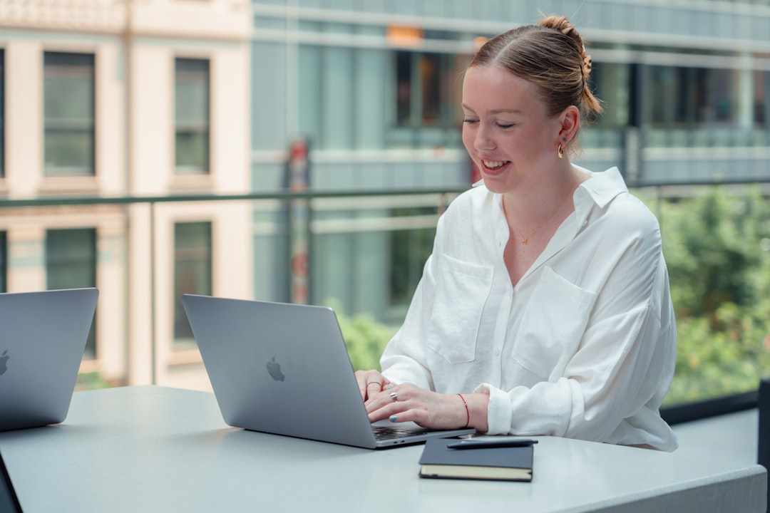 Une femme professionnelle travaille sur un ordinateur portable à l'intérieur de l'un des meilleurs espaces de coworking de New York City, avec des bureaux modernes en open-space.