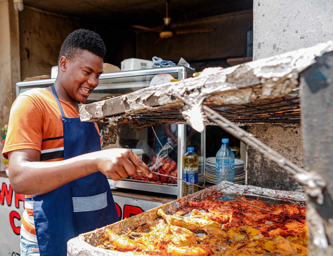 Um homem oeste-africano serve uma tigela de fufu e sopa em um restaurante movimentado do Bronx, representando o coração da comida oeste-africana