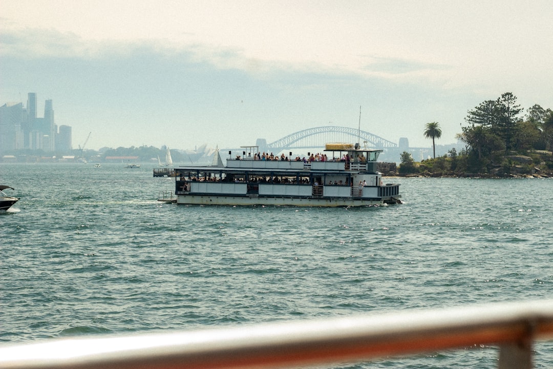 Uma mulher em pé no convés de uma embarcação do NYC Ferry com o horizonte de Manhattan visível ao fundo