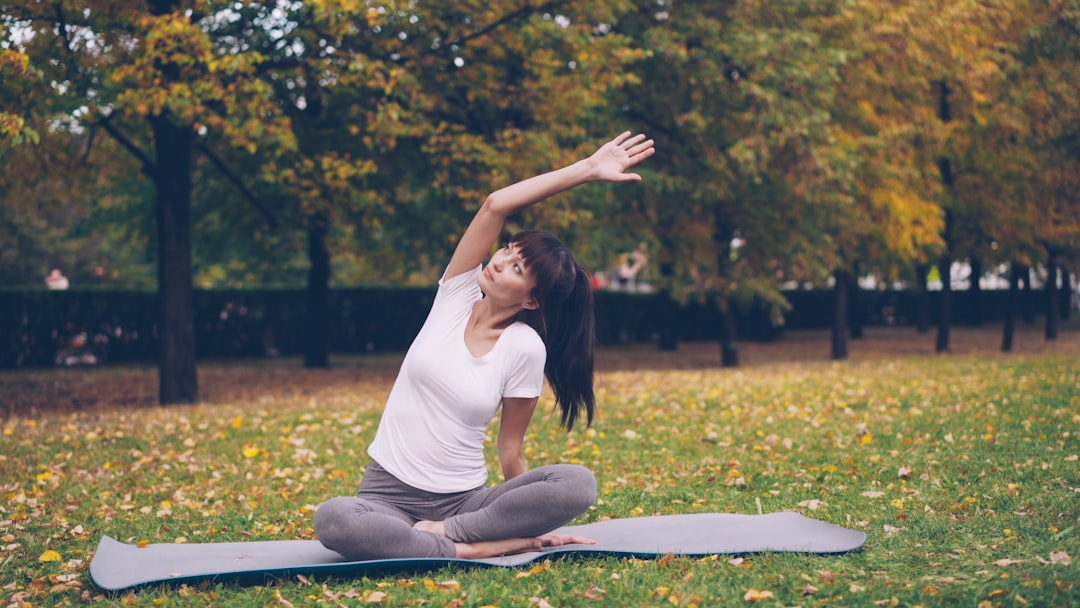 A woman practicing yoga on a mat at an outdoor fitness class in a New York City park