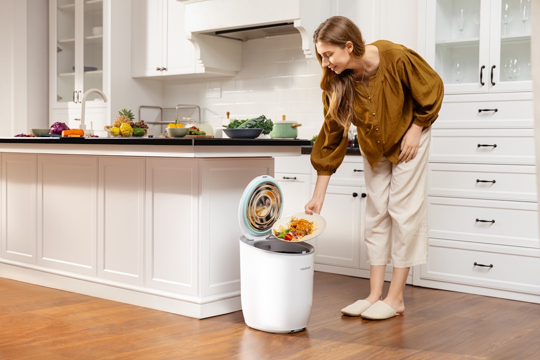 A woman placing food scraps into a countertop bin as part of her daily composting routine in a New York City kitchen.